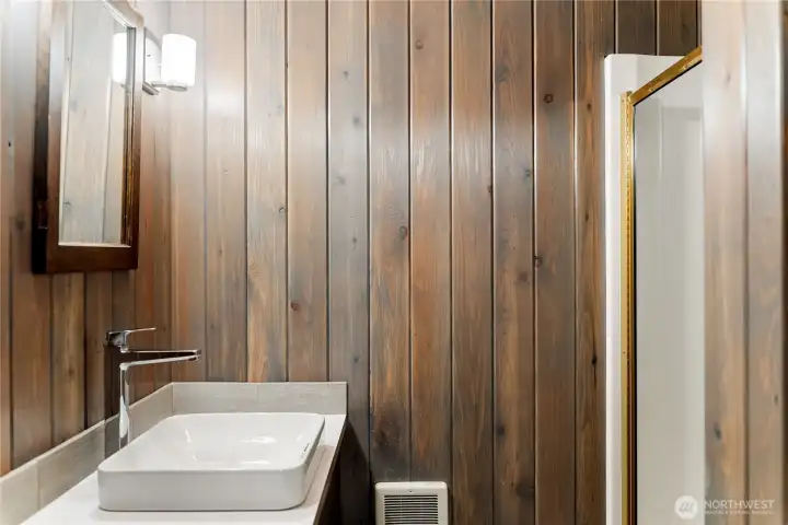 Updated downstairs bathroom with shower, warm wood accents, and clean finishes designed for comfort and convenience.