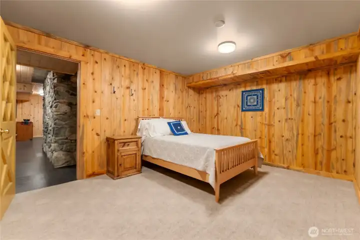 Versatile downstairs flex space ideal for a gear room, recreation room, media lounge, home office, workout area, or creative hobby space, with warm wood finishes and easy access to the lower level amenities.