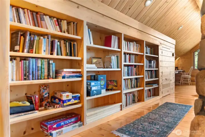 Custom built-in library shelving creates a warm and inviting reading nook, perfect for displaying books, artwork, and treasured collections, and space for nice home office.