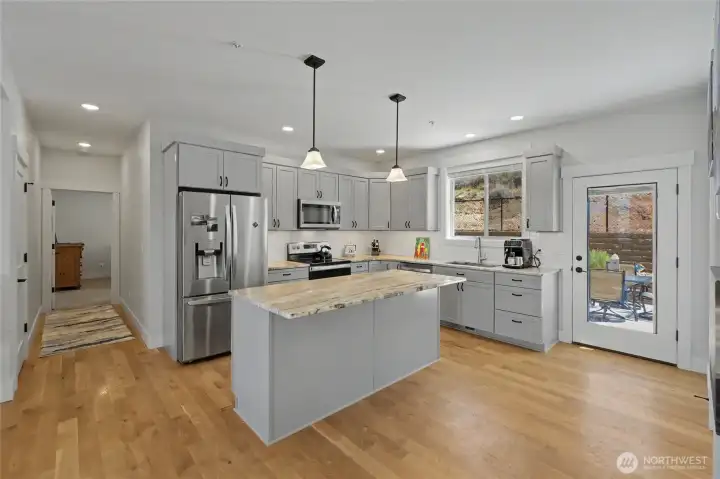 Kitchen with hall to Primary Bedroom and door to patio