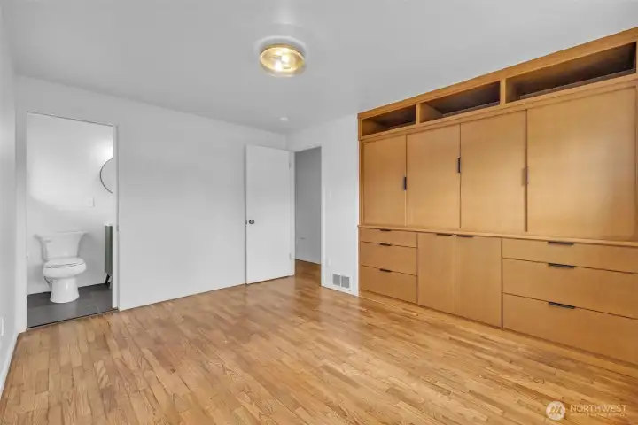 Primary bedroom with custom built ins, a perfect storage solution. Half bath attached to primary suite.