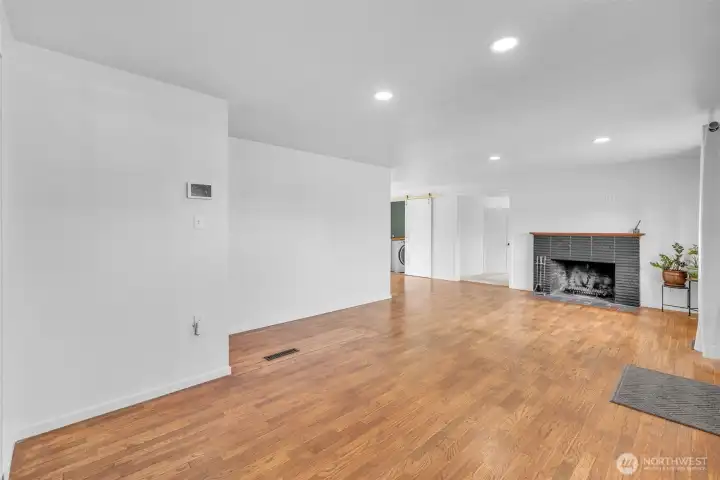 Hardwood floors, natural and overhead lighting, woodburning stove, view from the entry way and den.