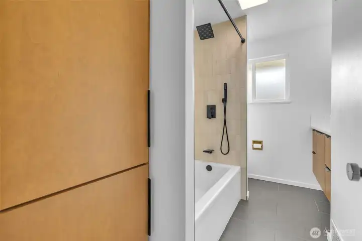 Full bath. Custom built storage and matching vanity. Tastefully updated tub/shower.