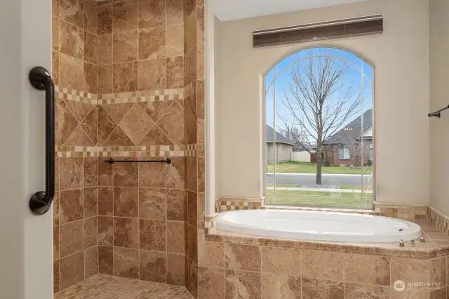 Large oval soaking tub with walk in shower.