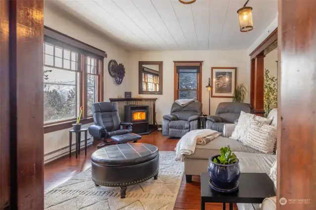 Warm and cozy living room with original wood floors and wood wrap window trim