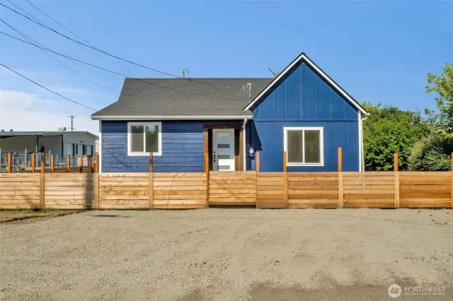 Front of home with new gravel and a nice new fence!