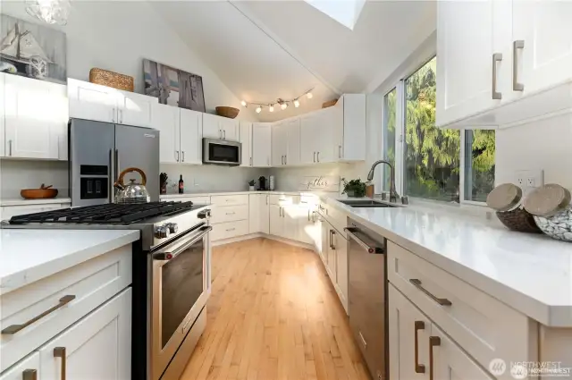 This gourmet kitchen features all-new cabinetry, sleek quartz countertops, appliances, and a custom island that offers a generous space for food prep, casual dining, and effortless entertaining.