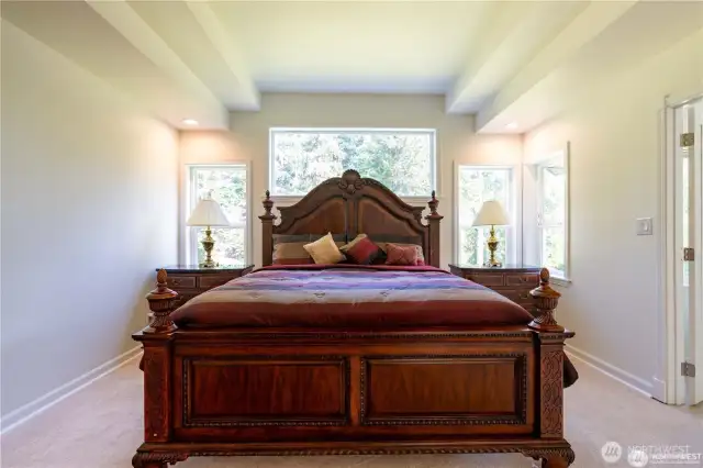 Master bedroom boasts stunning cove ceilings and an abundance of natural light, creating a serene and elegant retreat.