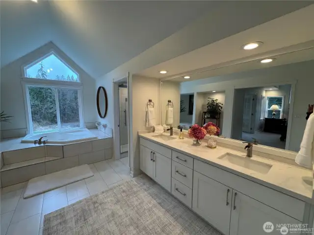 Master bedroom features a luxurious en suite bathroom that includes a jacuzzi soaking tub, double-head shower and double sinks providing a private and elegant retreat for comfort and relaxation.