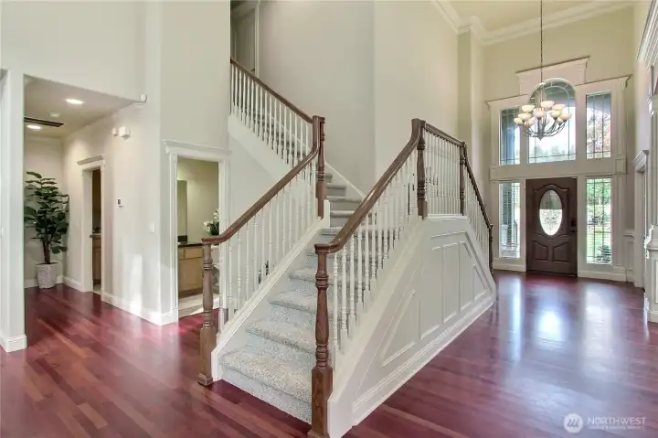 The double entrance grand staircase is a breathtaking centerpiece that elevates the entire home with timeless elegance and architectural flair. Flowing symmetrically from both sides, it creates a dramatic and graceful ascent to the upper level, perfect for making a lasting impression. This statement feature not only enhances the home's open and airy feel but also adds a sense of grandeur typically found in luxury estates.Tucked just off the base of the staircase, a private hall leads to the expansive primary suite, offering a quiet retreat with both convenience and seclusion.