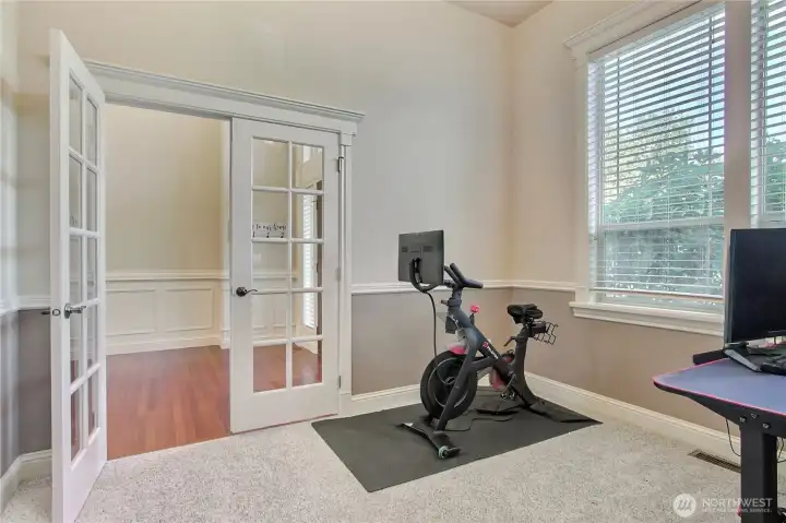 Classic French doors open to a flexible space perfect for a home office or a formal sitting room.