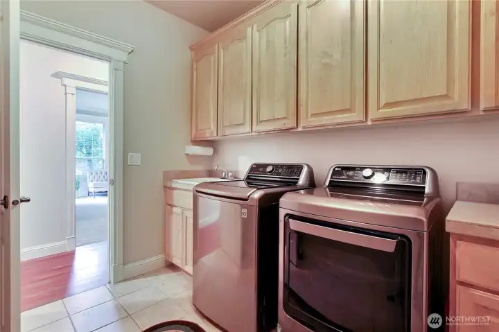 Conveniently located on the main floor, the laundry room sits just across from the primary suite, making daily routines a breeze. Thoughtfully designed for efficiency, it also offers direct access to the garage, perfect for unloading groceries or managing muddy shoes without tracking through the home. Plus, the laundry room cleverly stores the central vacuum hoses, keeping everything neat and easily accessible. This smart layout adds both functionality and ease to everyday living. Whether you're tackling laundry or heading out the door, everything is right where you need it.