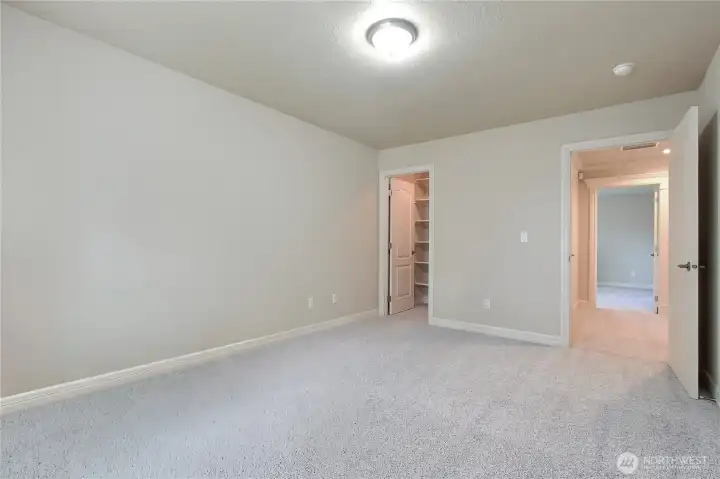 Bedroom one is spacious and bright, featuring plush carpeting that adds warmth and comfort underfoot. This inviting room also boasts a large walk-in closet, providing plenty of  storage.