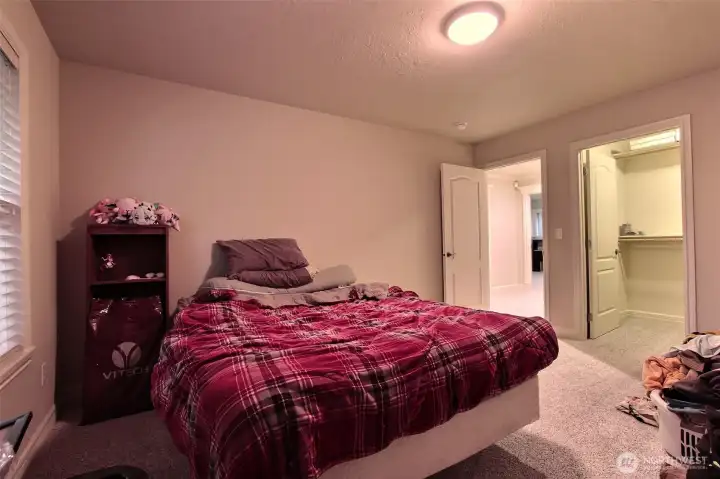 Bedroom three is occupied, spacious and bright, featuring plush carpeting that adds warmth and comfort underfoot. This inviting room also boasts a large walk-in closet, providing plenty of  storage.