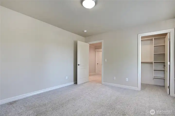 Bedroom two is spacious and bright, featuring plush carpeting that adds warmth and comfort underfoot. This inviting room also boasts a large walk-in closet, providing plenty of  storage.