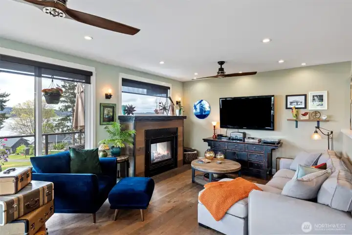 The main living area enjoys plank hardwood flooring and a double-sided gas fireplace, easily enjoyed from the deck as well.