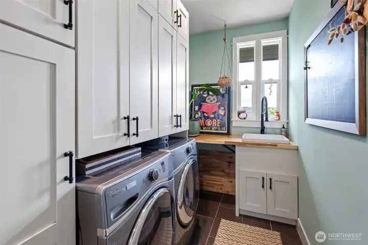 The utility room is also just off the kitchen.  All appliances remain with the home, including the washer and dryer.  There is also a stackable washer/dryer in the primary suite.
