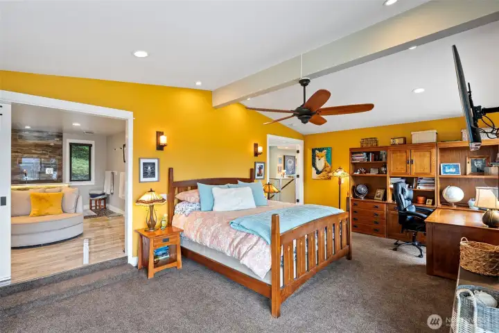 Another view of the primary suite located on the main level of this spectacular home.  Enjoy your own private deck from here and the incredible primary bathroom and vessel tub.