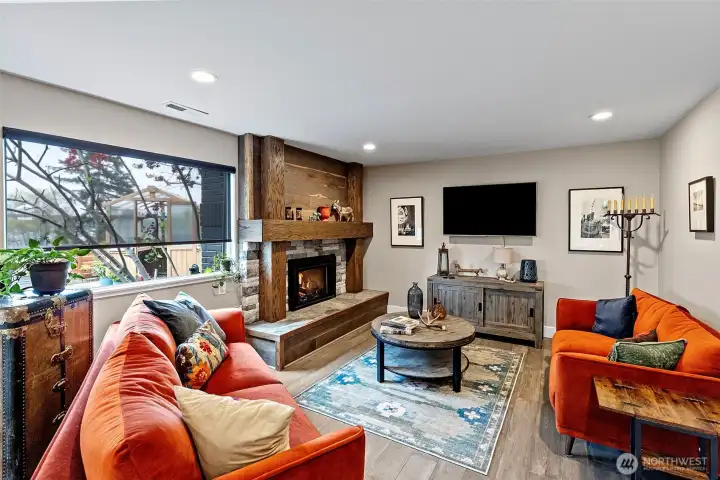 In the lower level of this home, you will find so many delightful amenities, including this lovely bonus room with gas fireplace and views to the greenhouse and lush garden.