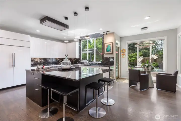 Stunning chef’s kitchen with sleek quartz countertops, oversized waterfall island, premium appliances, and designer lighting.