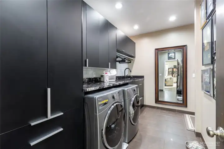 Remodeled laundry room with custom cabinetry, stone counters, thoughtfully designed for style and function.