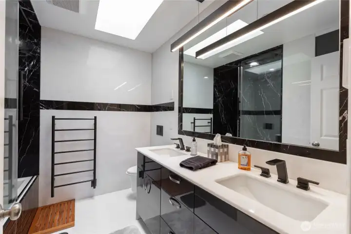 Fully remodeled bath with dual vanity, modern fixtures, radiant heated floors, and a heated towel bar, as well as a skylight added!