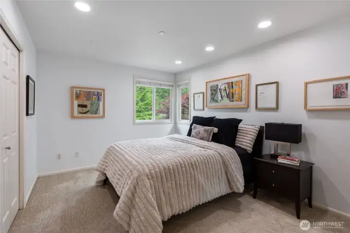Bedroom #3 is  well lit with clean, modern finishes.