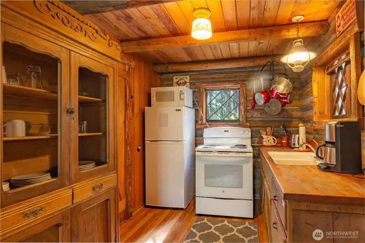 A quaint built-in cupboard stores all the dishes in the kitchen.