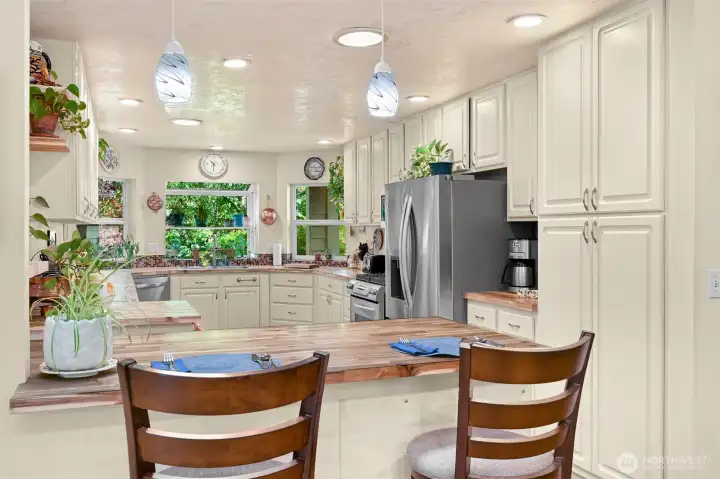 Beautifully renovated kitchen offers acacia butcher block countertops with ample prep space.