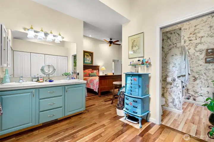 Primary bathroom with walls of closet space and separate shower room.