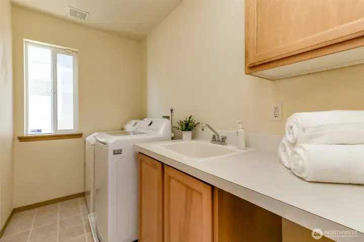 Laundry room with deep utility sink and cabinet storage. Laundry room with deep utility sink and cabinet storage.