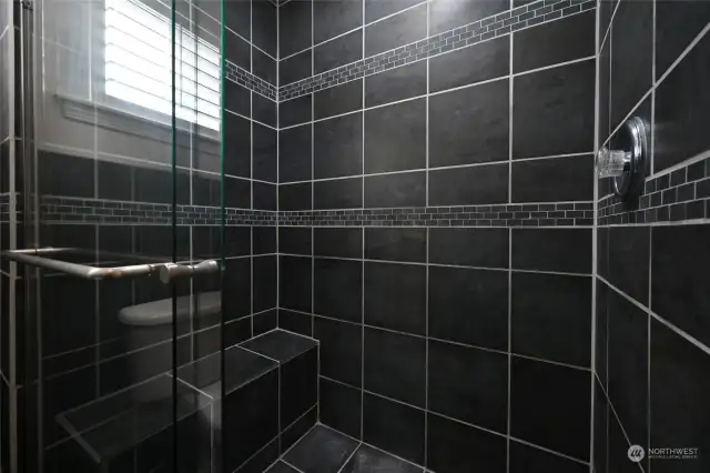 The luxurious shower in the master bath with the built-in bench.