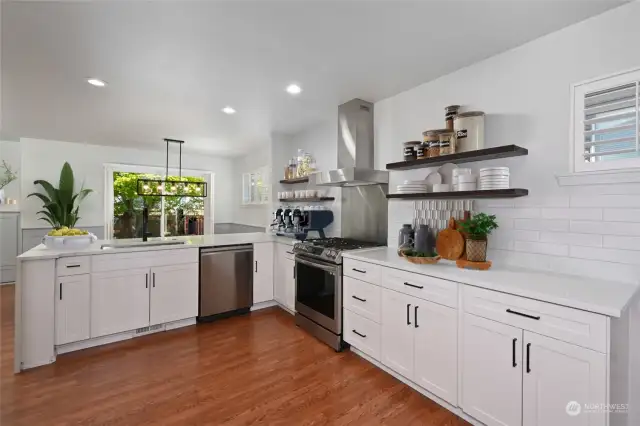 Recently updated kitchen with new counters and cabinets. Gas range with stainless hood. Much more to see in this lovely room. Photo virtually staged.