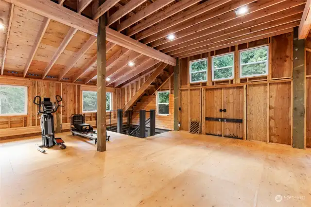 Oversize interior industrial style staircase has beautiful fir stair treads, and custom metal railings.