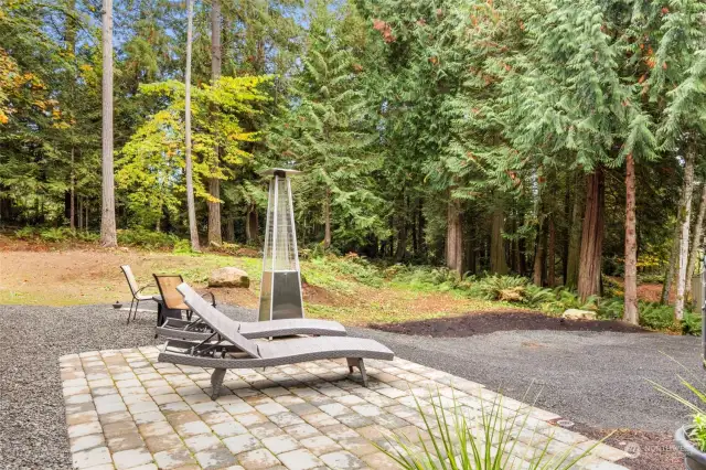 Kick back with a beverage on the paver patio overlooking the sun dappled forest.