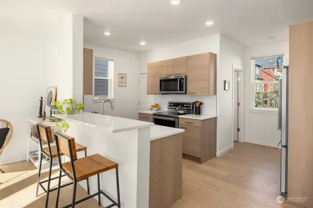 Gorgeous modern kitchen with stainless steel appliances and quartz counters, plus a countertop bar