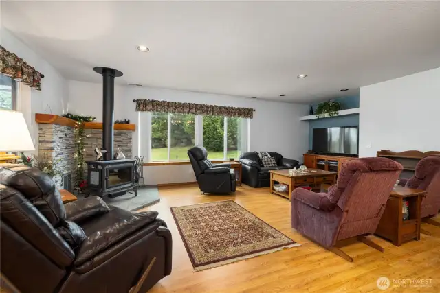 Cozy living room complete with a wood stove and hand cut stone backing.