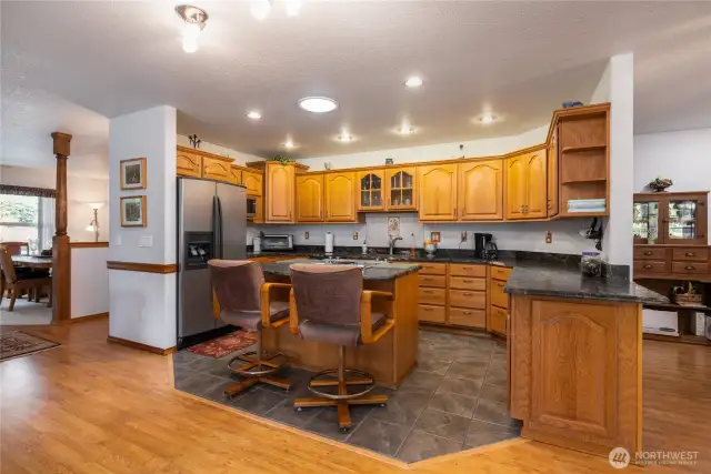 Kitchen is open to the living room with a cozy fireplace and another dining room to the right of this photo.