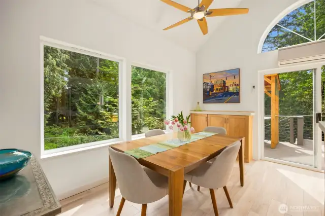 This invitingl dining space is graced by windows overlooking the yard and the woods just beyond. The porcelain tiles continue from the kitchen and entry, providing cohesive design as well as carefree living.