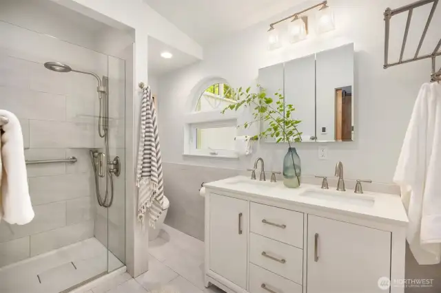 The primary bathroom offers heated floors, porcelain tile, and dual undermount sinks. Timeless, elegant finishes are a welcome reprieve from trendy renovations.