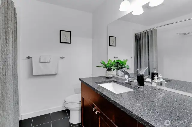 Full bath has also been updated with slab quartz, cherry cabinets and tile flooring.