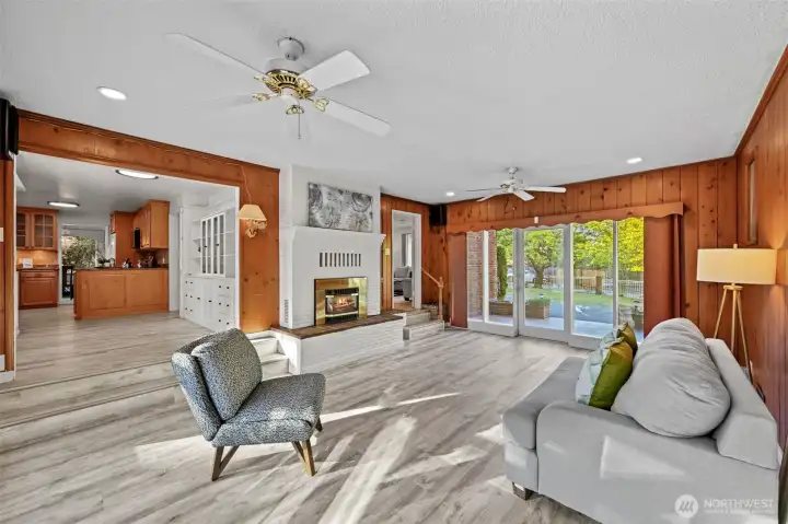Spacious family room with natural light, wood accents, and fireplace charm