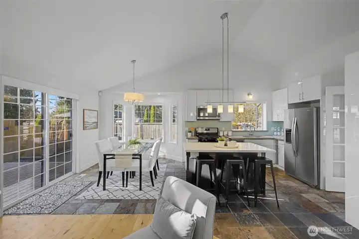 The open kitchen is designed for both function and style, featuring durable quartz countertops, hard-surface cabinetry with a long-lasting finish, stainless steel appliances and a gas cooktop. A spacious center island provides generous prep space and casual seating, making it ideal for everyday living and entertaining.