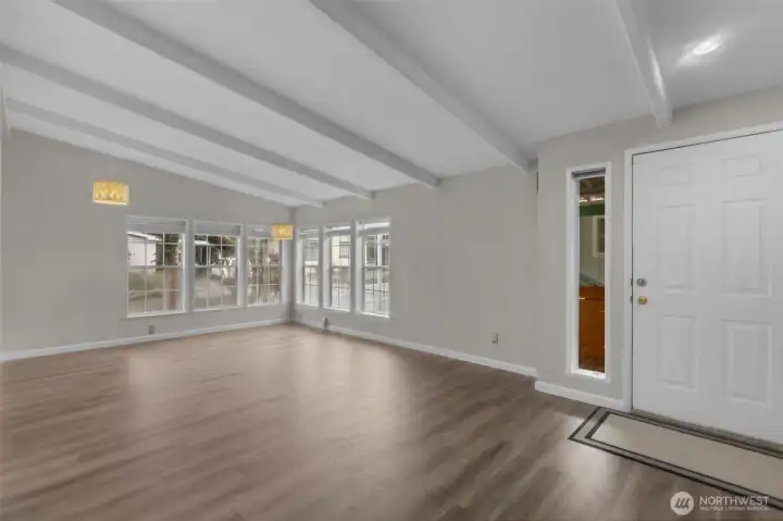 Enter into a Spacious Living Room that has vaulted ceilings, gleaming Luxury Vinyl Plank (LVP) Flooring and cool designer paint colors.  NW Facing windows allow a lot of light to filter into the room making it light and bright!