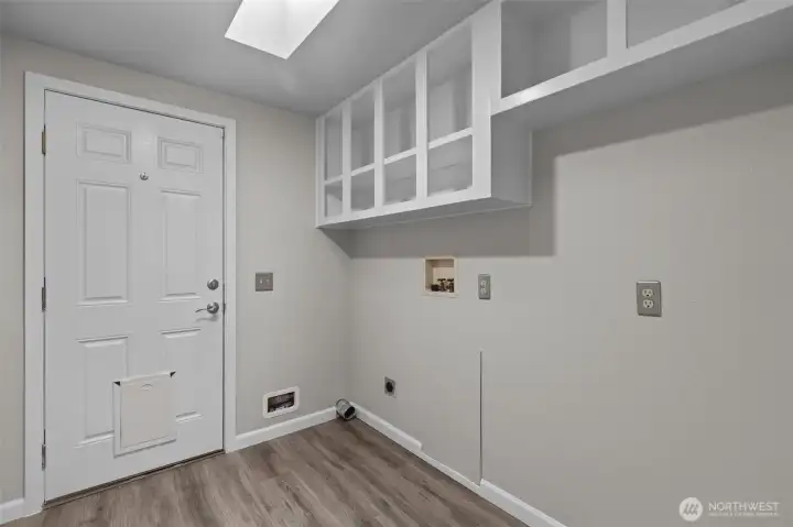 Spacious Laundry Room/Mud Room that has a door leading to the Covered Deck on the south side of the home.