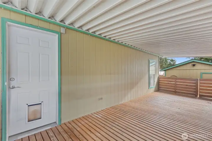 From the Covered Deck, looking at the Laundry Room/Mud Room Door.  There is a gate (right side of picture) that leads to the Storage Shed and the Back Yard.