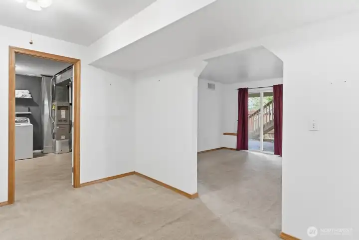 Upon entering the lower level, a central foyer provides access to the utility room, the living room, and the adjoining bedrooms, creating a well-organized and functional layout.