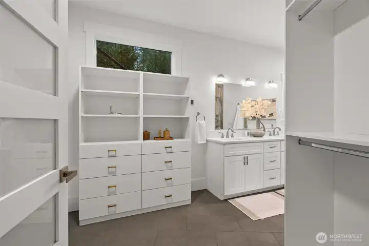 A spacious walk-through closet with custom built-ins for streamlined, stylish organization.