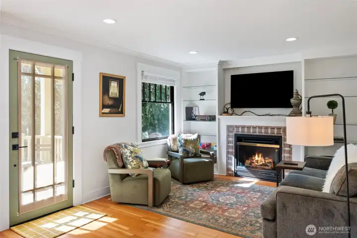 A gas fireplace is the centerpiece of the living room, where built-in glass shelving allows for fun decorating in all seasons. (The television will convey with the home.)