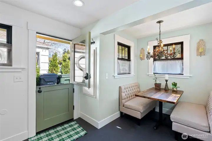 A Dutch-door allows the outdoors in and is a quaint addition to this charming kitchen and nook area.  A vintage chandelier has been added for charm and elegance.